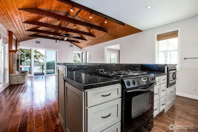 a kitchen with granite countertop stainless steel appliances white cabinets and a sink