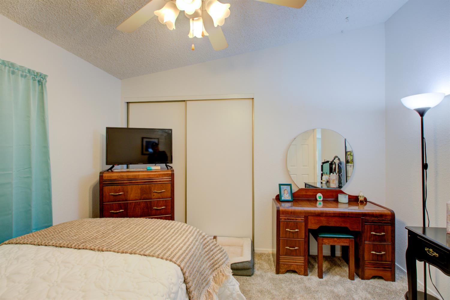 500 North Tully Road, Unit 64 Turlock, CA 95380 - Photo 18 of 38 a bedroom with a bed and a chandelier