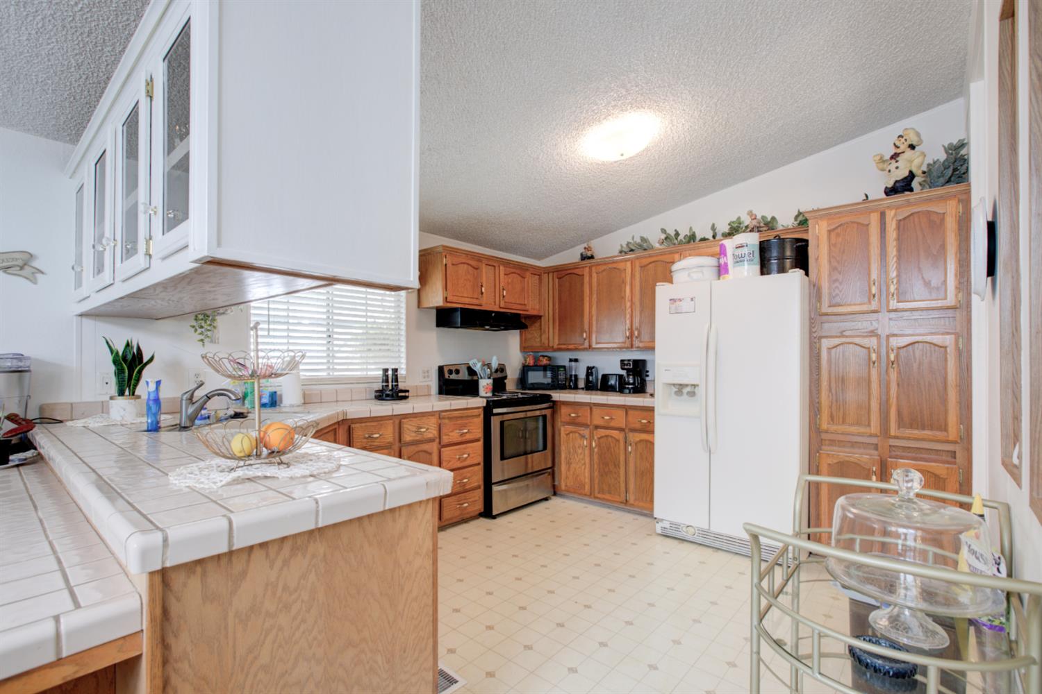 500 North Tully Road, Unit 64 Turlock, CA 95380 - Photo 26 of 38 a kitchen with refrigerator a stove a sink and cabinets