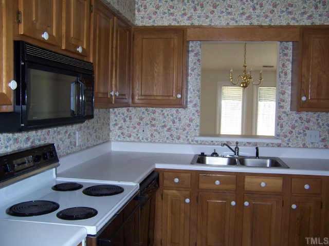 6712 Twin Tree Court Raleigh, NC 27613 - Photo 4 of 9 a kitchen with a sink a stove and cabinets