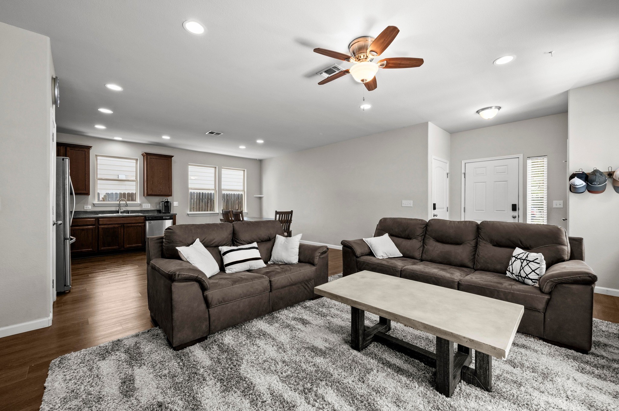 Living area with dark wood-style flooring, ceiling fan, recessed lighting, and baseboards