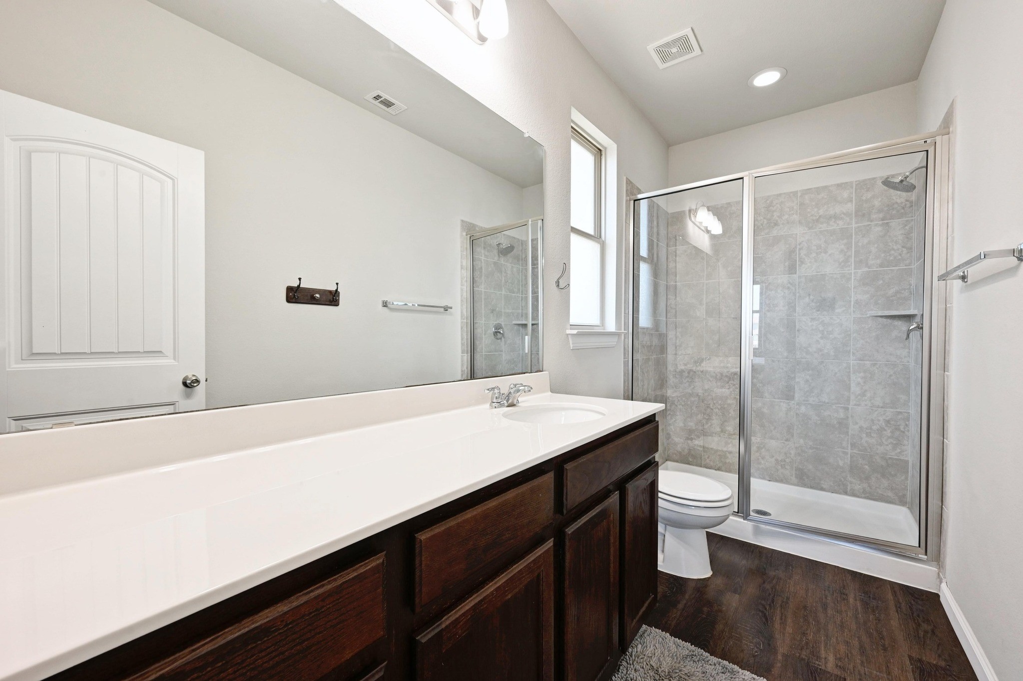 328 Triumph Road Buda, TX 78610 - Photo 12 of 18 Bathroom with toilet, vanity, a stall shower, wood finished floors, and recessed lighting