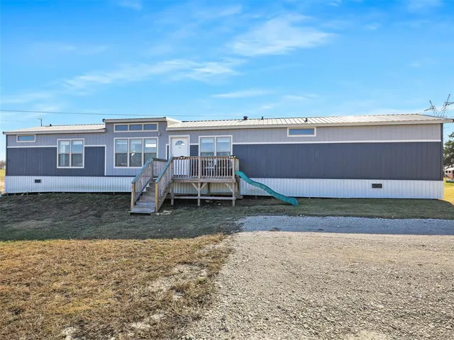 a view of a backyard with lawn chairs
