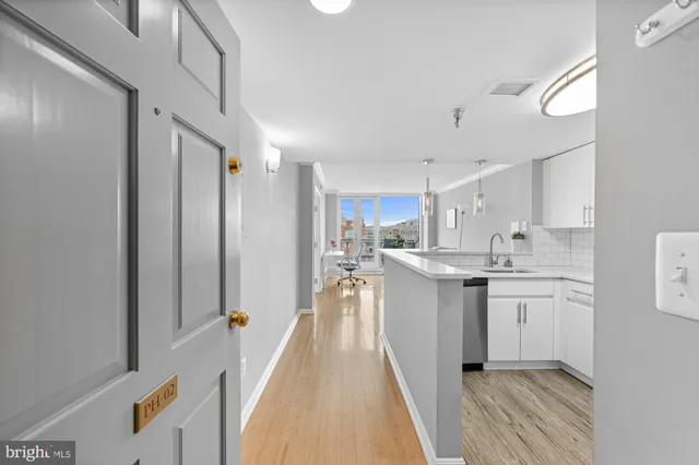 a kitchen with white cabinets and sink