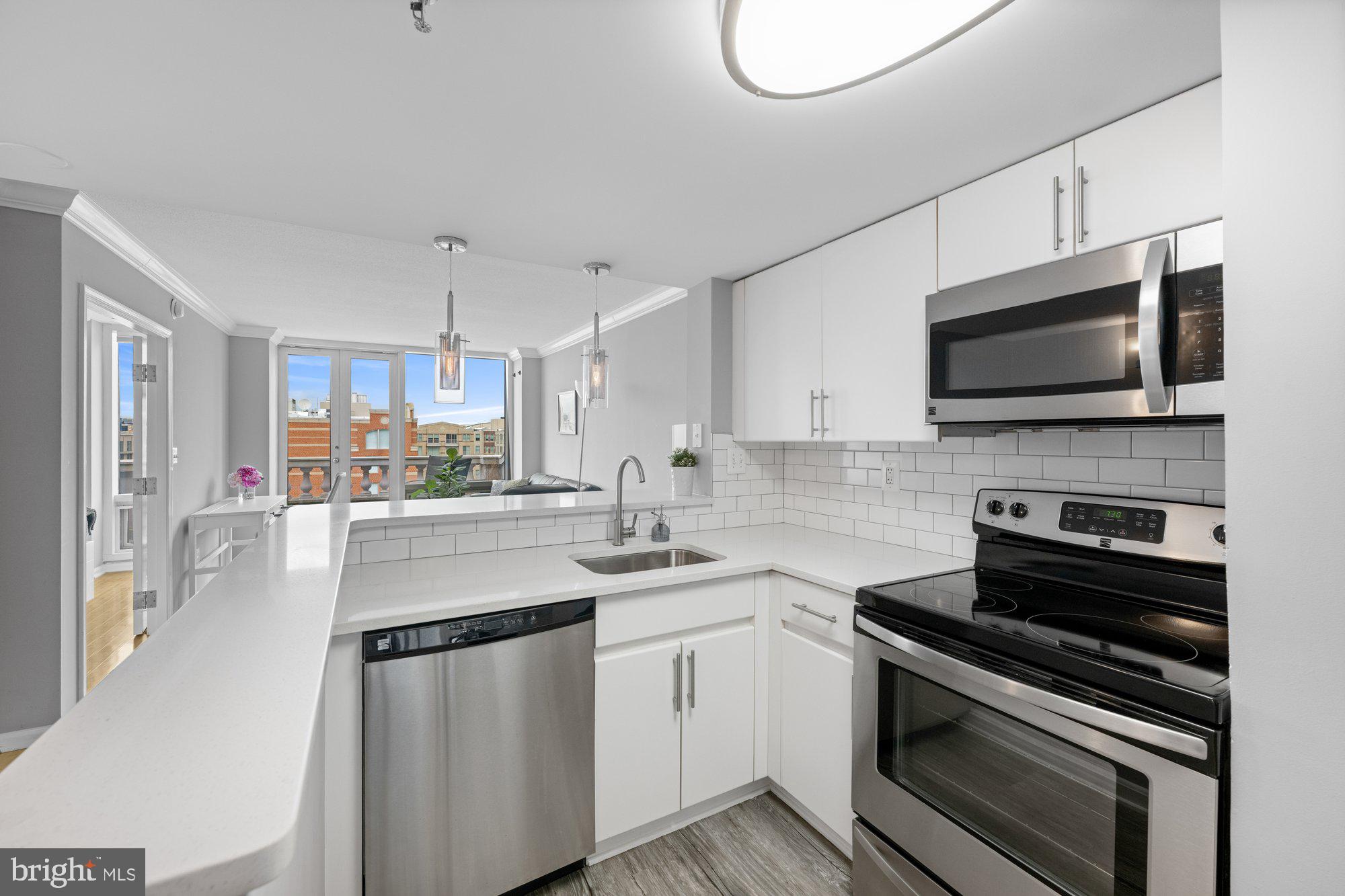 701 Pennsylvania Avenue Northwest, Unit PH2 Washington, DC 20004 - Photo 4 of 19 a kitchen with stainless steel appliances a stove microwave and sink