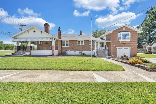 an empty room with wooden floor fireplace and windows