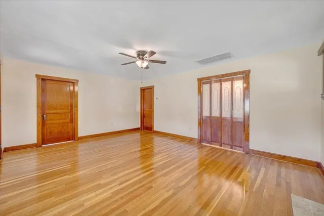 a kitchen with stainless steel appliances kitchen island granite countertop a refrigerator a sink dishwasher a stove with wooden cabinets and floor