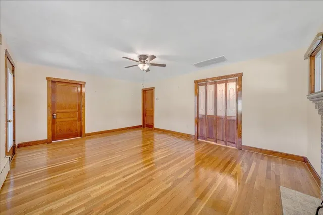 a view of an empty room with wooden floor