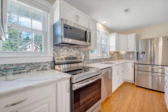 a bathroom with a granite countertop sink a toilet and vanity