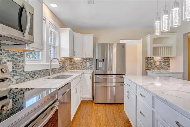 a kitchen with a refrigerator sink stove and cabinets