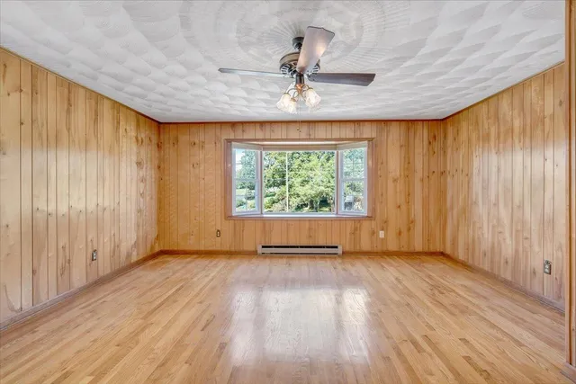 a view of a house with a big yard and large trees