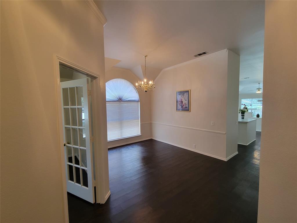 2913 Rush Creek Road McKinney, TX 75072 - Photo 17 of 32 Entryway looking at dining room with chandelier, dark wood-style flooring, vaulted ceiling, and ornamental molding