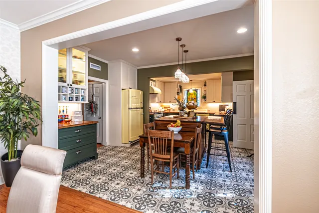 a open kitchen with stainless steel appliances granite countertop a stove refrigerator dining table and chairs