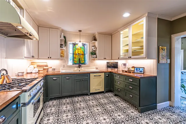 a kitchen with stainless steel appliances granite countertop a sink stove refrigerator and cabinets