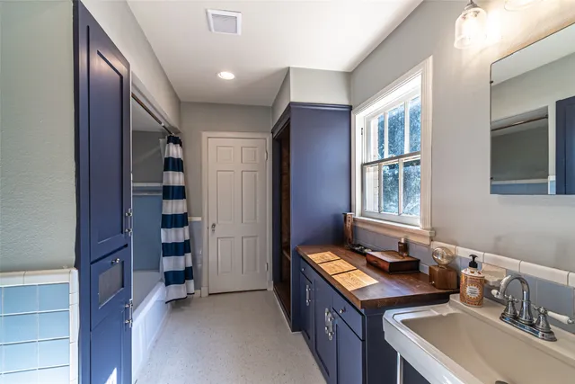 a bathroom with a double vanity sink a mirror and a bathtub