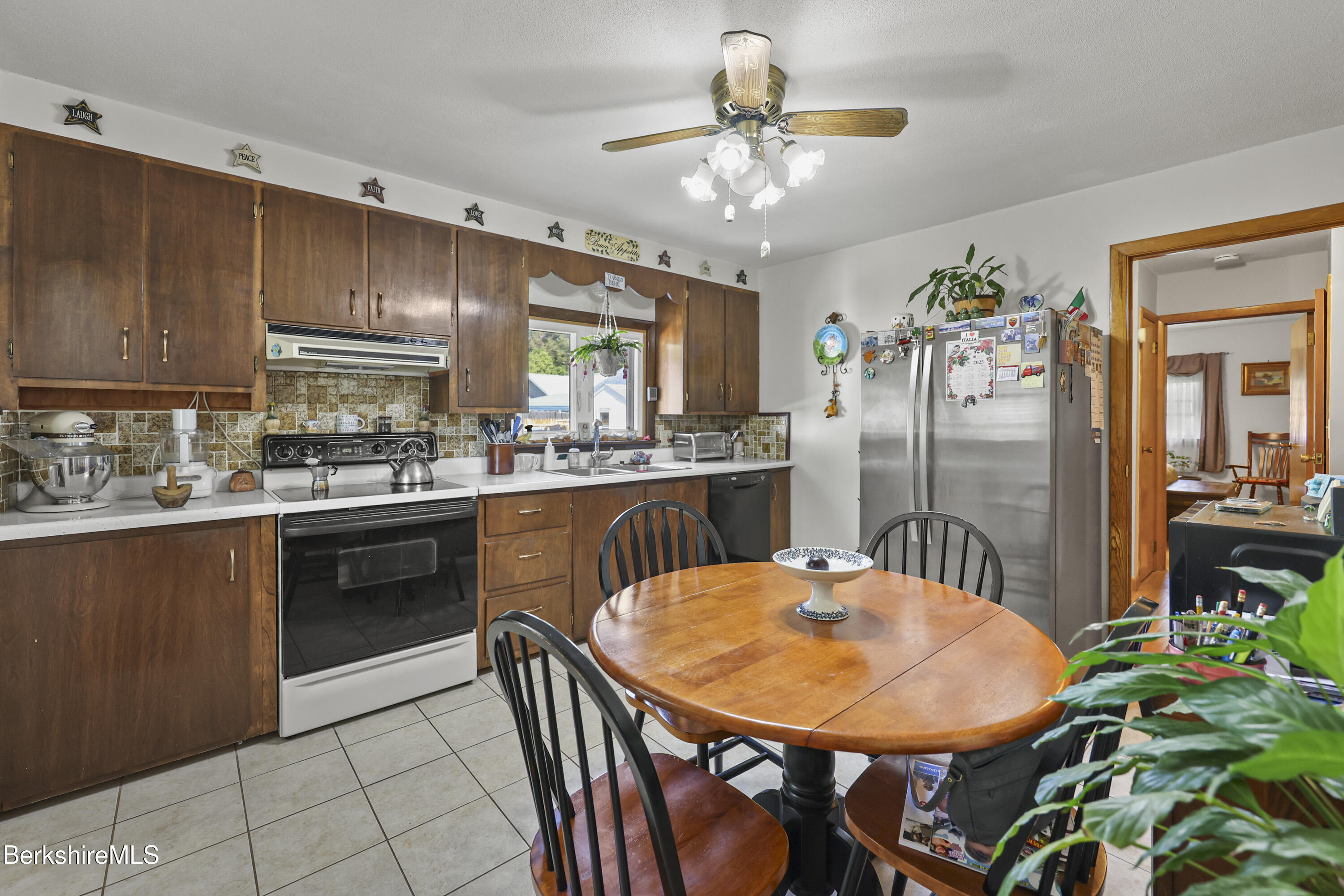 46 Lucille Street Pittsfield, MA 01201 - Photo 11 of 33 a kitchen with stainless steel appliances kitchen island granite countertop a refrigerator a stove a sink dishwasher with a dining table and chairs