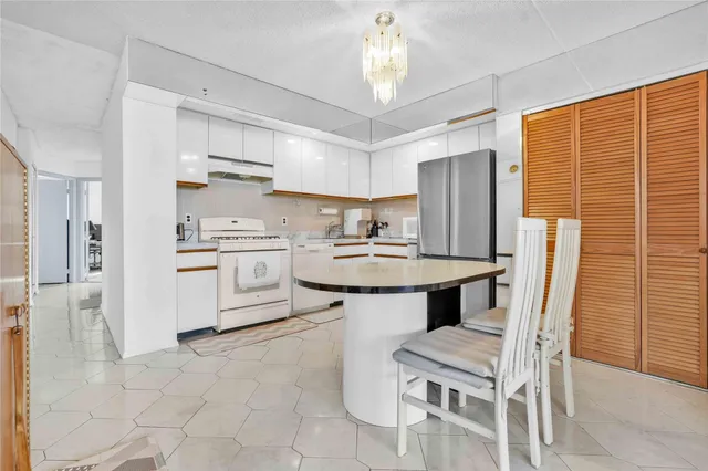 a kitchen with stainless steel appliances a table chairs refrigerator and microwave