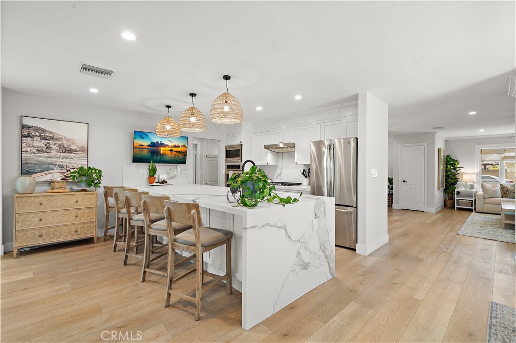 8741 La Roca Avenue Fountain Valley, CA 92708 - Photo 16 of 50 Quartz peninsula with waterfall and seating with pendant lights
