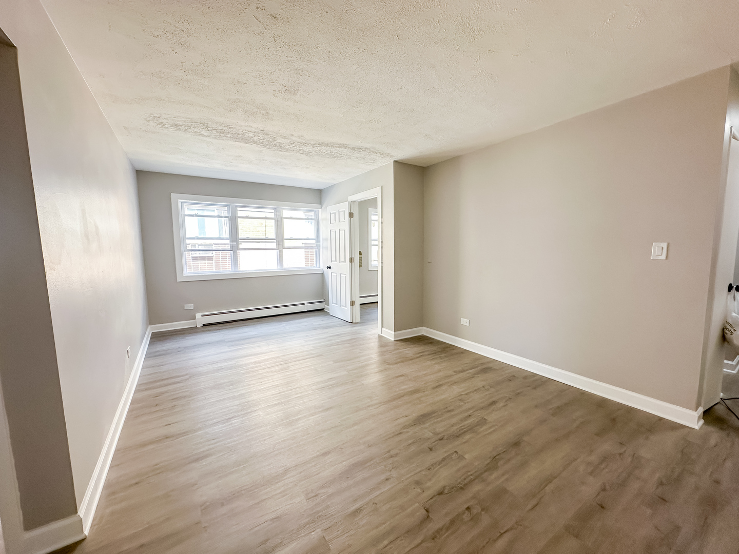 4300 North Keystone Avenue, Unit 3C Chicago, IL 60641 - Photo 3 of 10 an empty room with wooden floor and windows