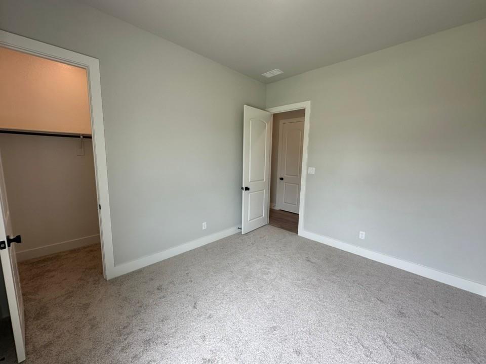 390 Cobb Road Leonard, TX 75452 - Photo 18 of 26 Carpeted room with light gray walls, white trim, and a closet featuring a single hanging rod