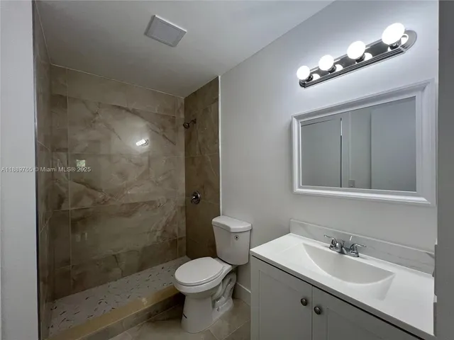 a bathroom with a toilet a sink and mirror