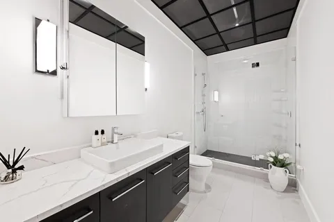 a bathroom with a double vanity sink toilet and a mirror