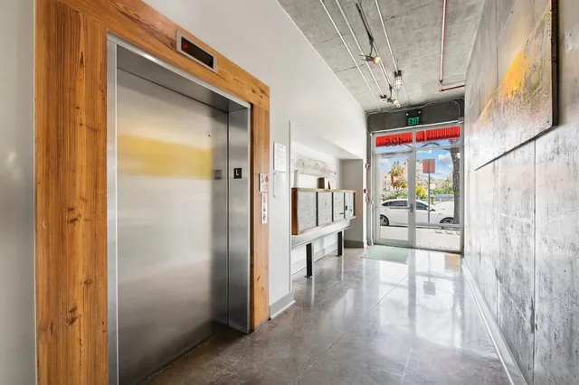 a view of a hallway with a dining table and chairs