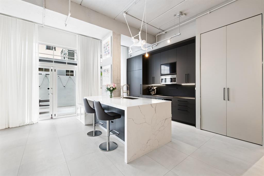 425 North Andrews Avenue, Unit 206 Fort Lauderdale, FL 33301 - Photo 2 of 17 a kitchen with kitchen island a counter top space a sink stainless steel appliances and cabinets