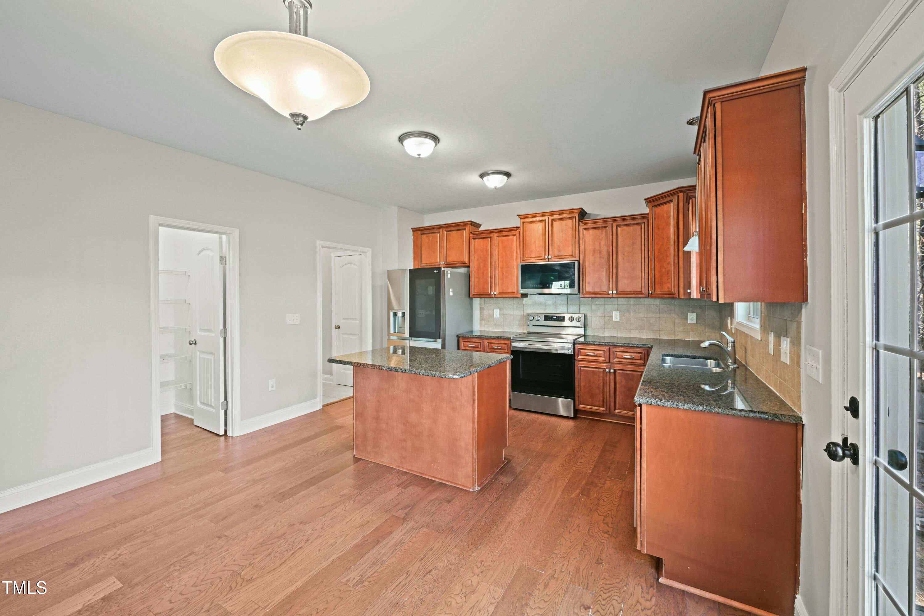 64 Valor Circle Bunnlevel, NC 28323 - Photo 15 of 34 a kitchen with stainless steel appliances granite countertop a refrigerator a stove top oven and a sink with wooden floor
