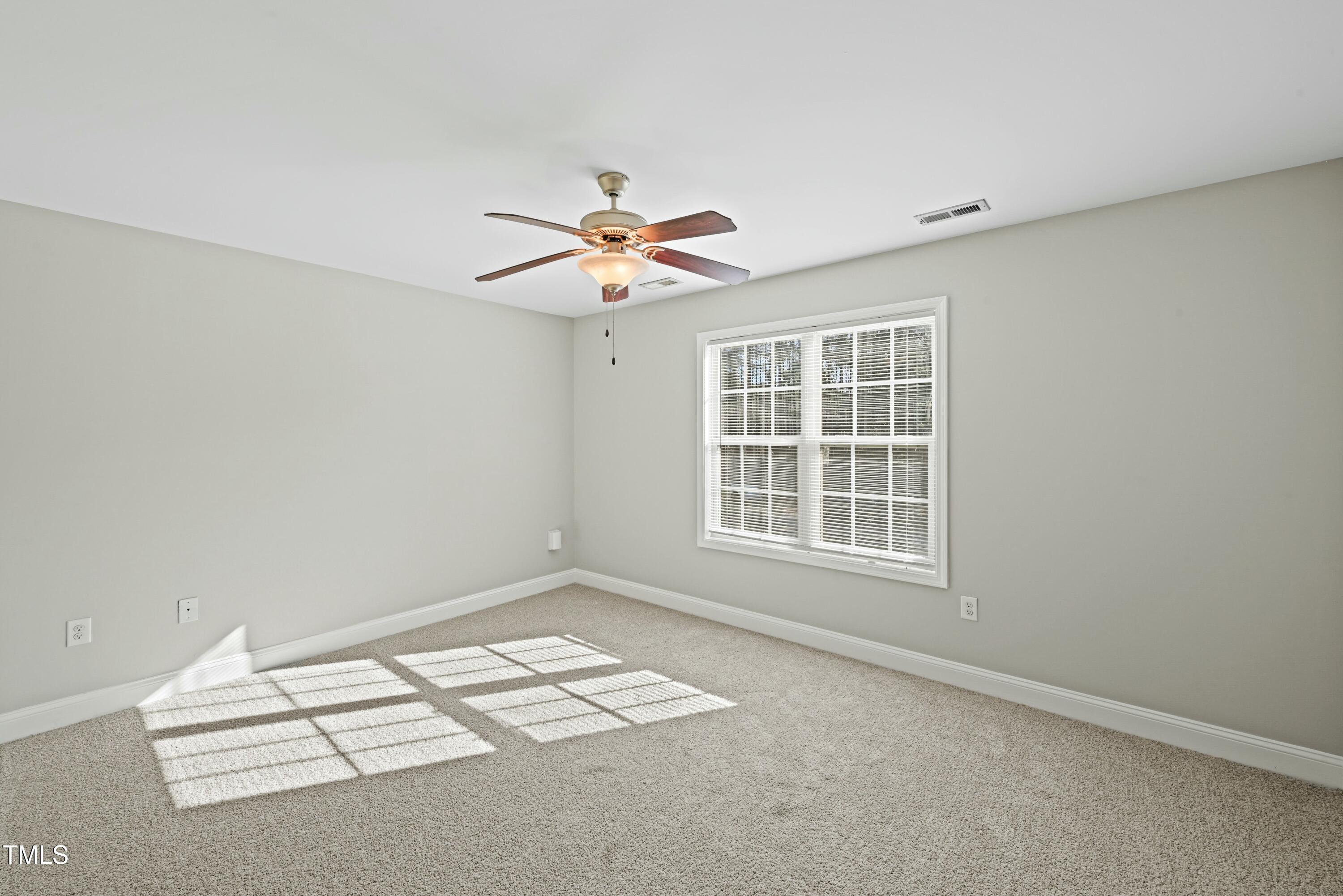 64 Valor Circle Bunnlevel, NC 28323 - Photo 24 of 34 an empty room with chandelier fan and windows