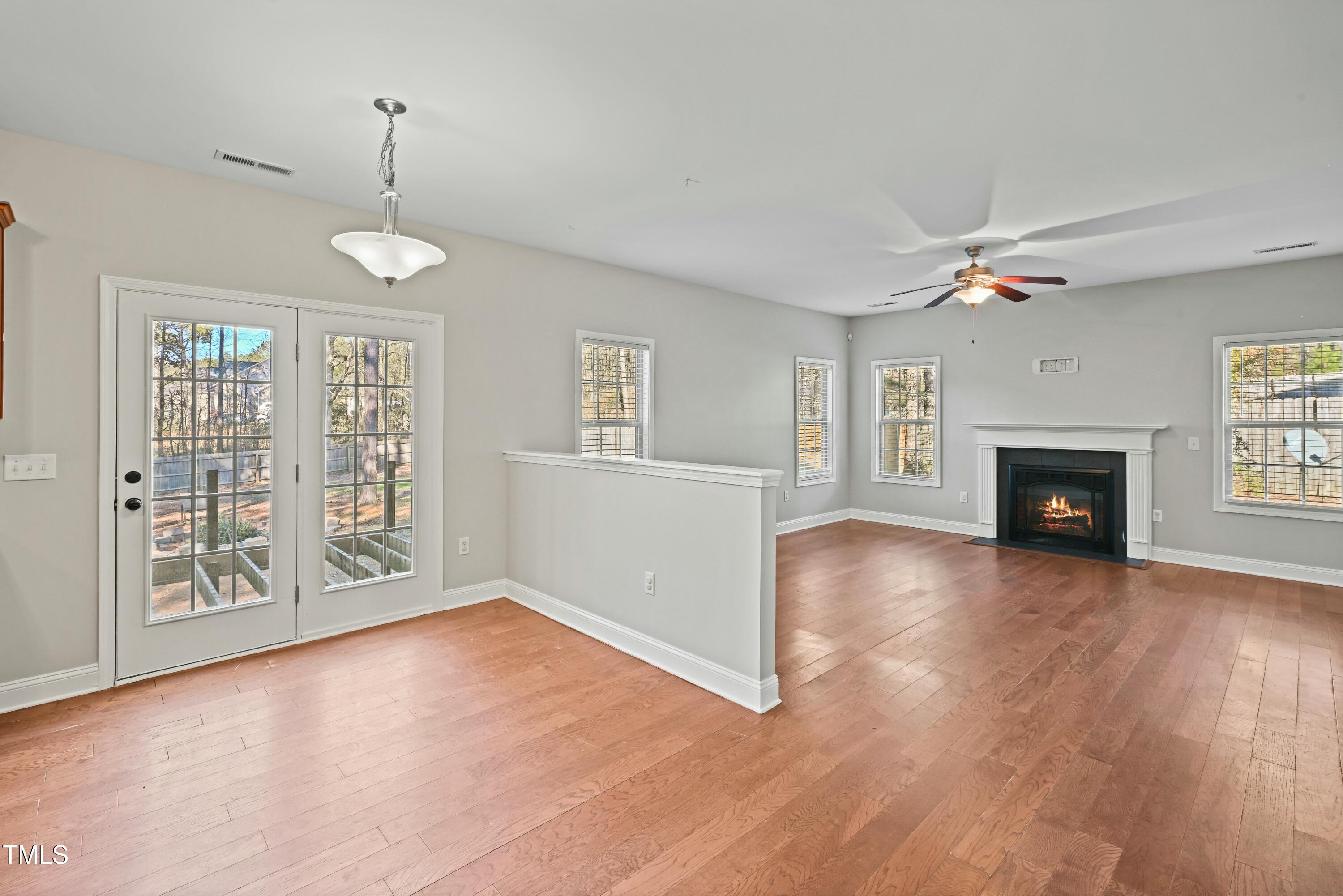 64 Valor Circle Bunnlevel, NC 28323 - Photo 10 of 34 an empty room with wooden floor fireplace and windows