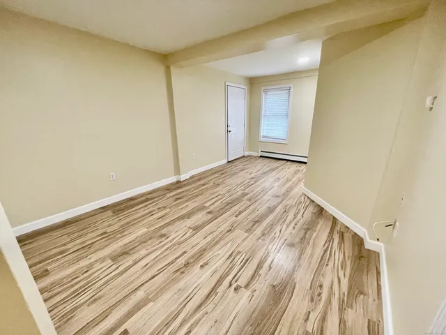 a view of a room with wooden floor and bench