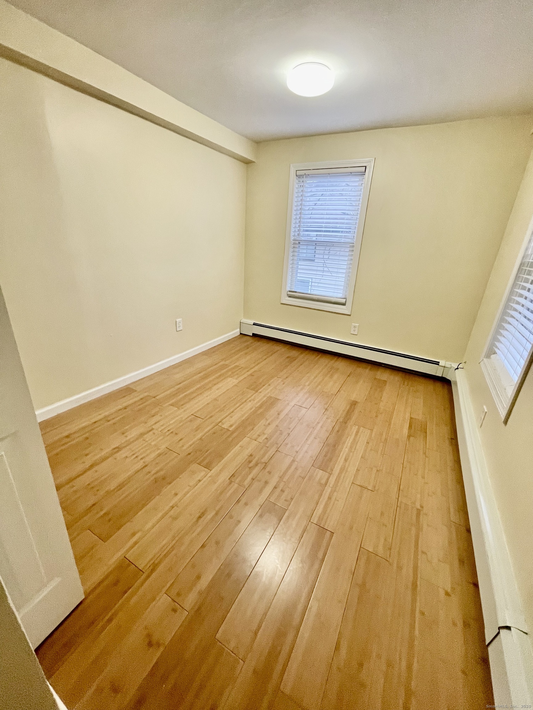 92 West Main Street, Unit 6 Vernon, CT 06066 - Photo 6 of 8 a view of an empty room with wooden floor and a window