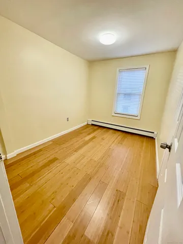 a view of a room with wooden floor and a window