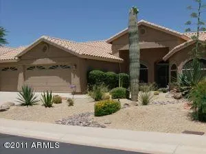 a front view of a house with a yard and potted plants