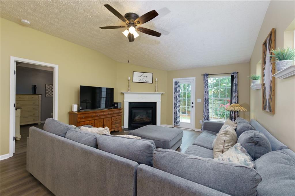 67 Granite Court Dallas, GA 30132 - Photo 11 of 27 a living room with furniture ceiling fan and a fireplace