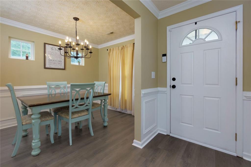 67 Granite Court Dallas, GA 30132 - Photo 2 of 27 a dining room with wooden floor a chandelier a wooden table and chairs