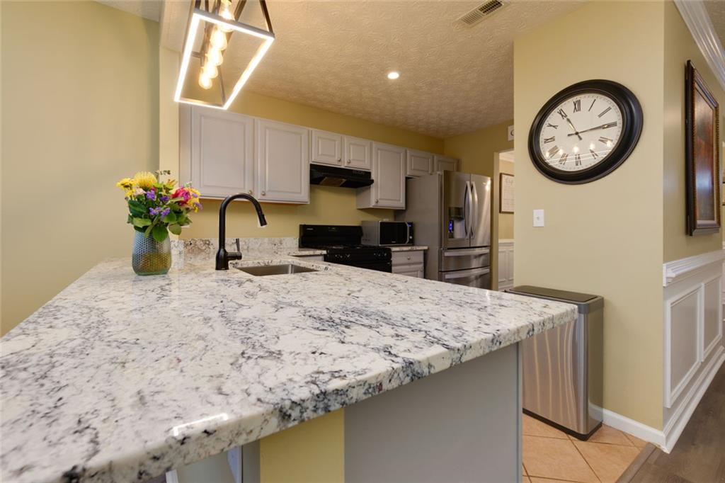 67 Granite Court Dallas, GA 30132 - Photo 7 of 27 a kitchen with stainless steel appliances granite countertop a sink a stove top oven a chimney and a refrigerator