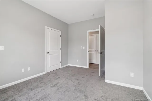 an empty room with closet and a bathroom