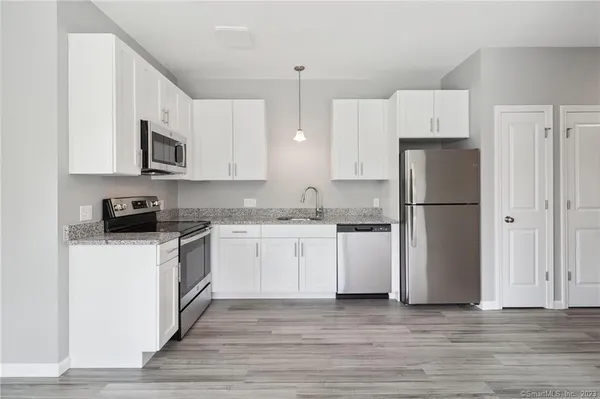 a kitchen with a refrigerator and a stove top oven