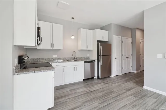 a kitchen with a refrigerator sink and cabinets