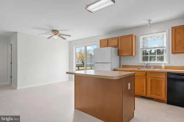 a kitchen with stainless steel appliances a stove a sink and a refrigerator with white cabinets