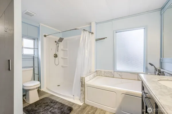 a bathroom with a granite countertop sink toilet and shower