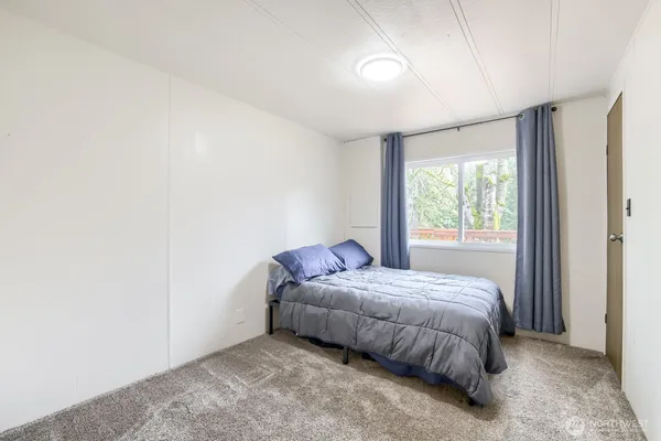 a bed sitting in a spacious bedroom next to a window