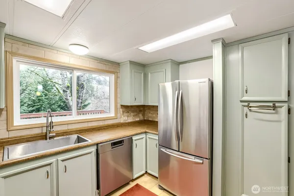 a kitchen with stainless steel appliances a refrigerator sink and window