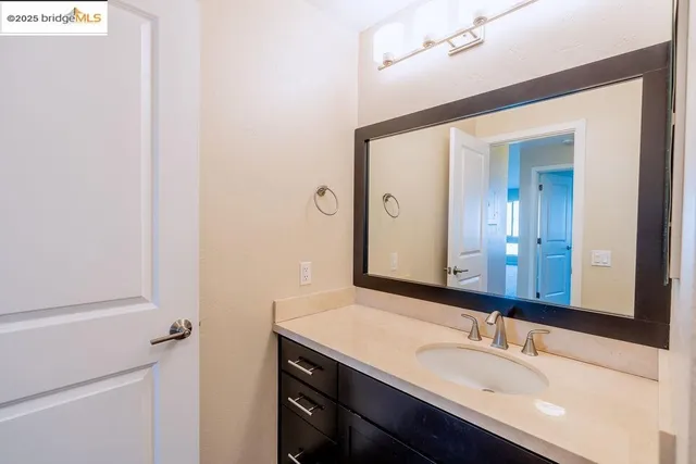 a bathroom with a granite countertop sink and a mirror