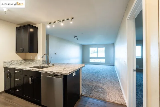 a bathroom with a granite countertop sink a toilet a mirror and window