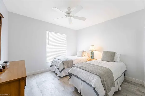 a bedroom with two beds and a ceiling fan