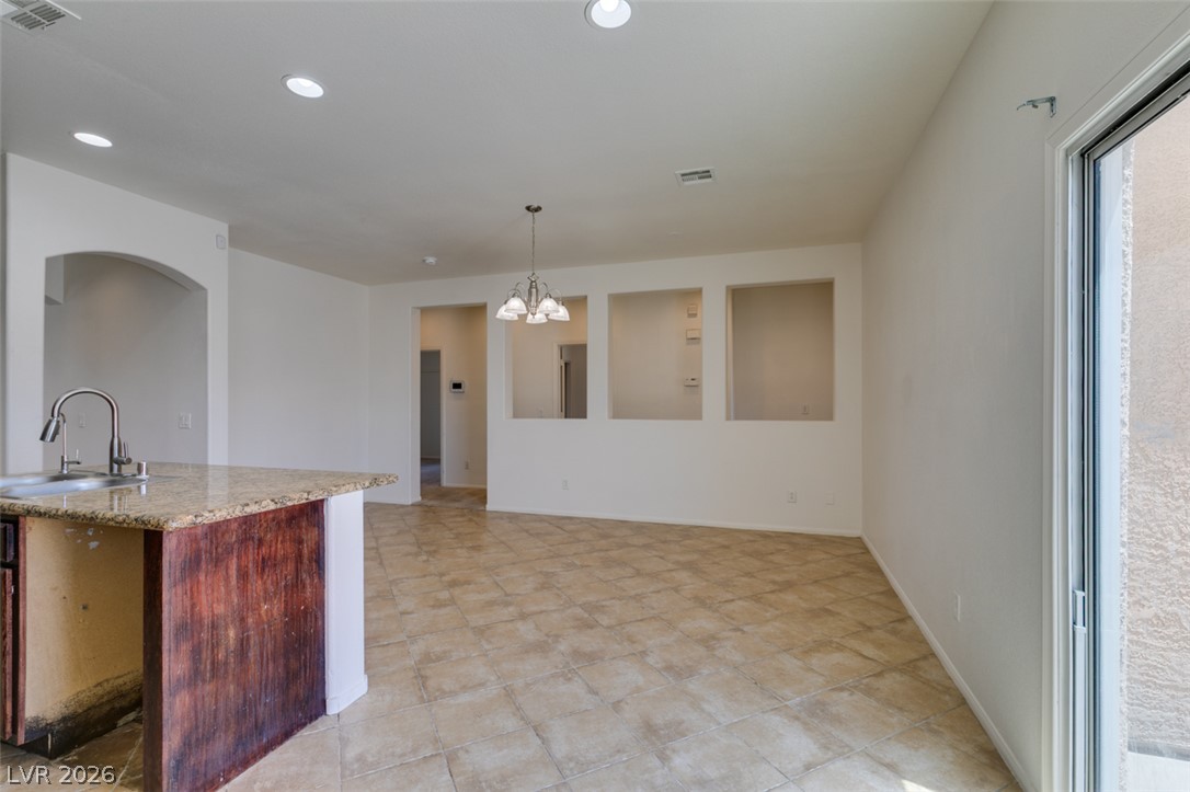 5150 Riverside Run Court North Las Vegas, NV 89081 - Photo 27 of 50 A spacious, open concept living area boasts a kitchen island with granite counters and tiled flooring.