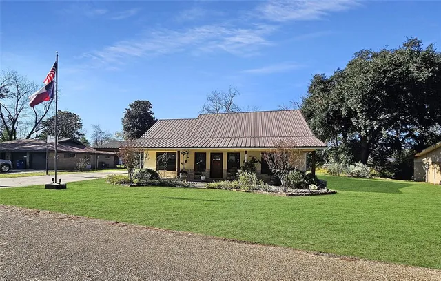 a view of a house with a yard and sitting area